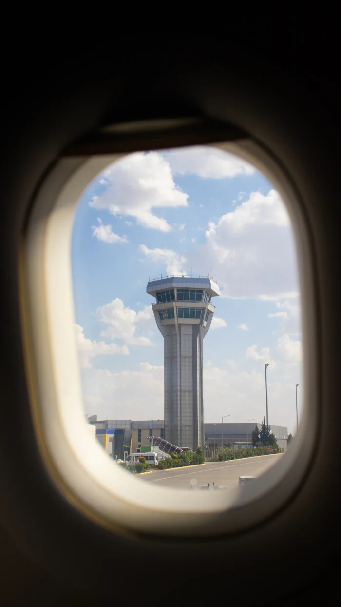 Airport control tower framed by an aircraft window